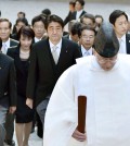 Japan's Prime Minister Shinzo Abe, center, and his cabinet ministers, escorted by a Shinto priest, arrive at the Grand Shrine of Ise, central Japan, for offering a new year's prayer Monday, Jan. 5, 2015.  Japanese Prime Minister Abe said Monday that his government would express remorse for World War II on the 70th anniversary of its end in August. (AP Photo/Kyodo News)