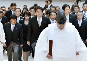 Japan's Prime Minister Shinzo Abe, center, and his cabinet ministers, escorted by a Shinto priest, arrive at the Grand Shrine of Ise, central Japan, for offering a new year's prayer Monday, Jan. 5, 2015. Japanese Prime Minister Abe said Monday that his government would express remorse for World War II on the 70th anniversary of its end in August. (AP Photo/Kyodo News)