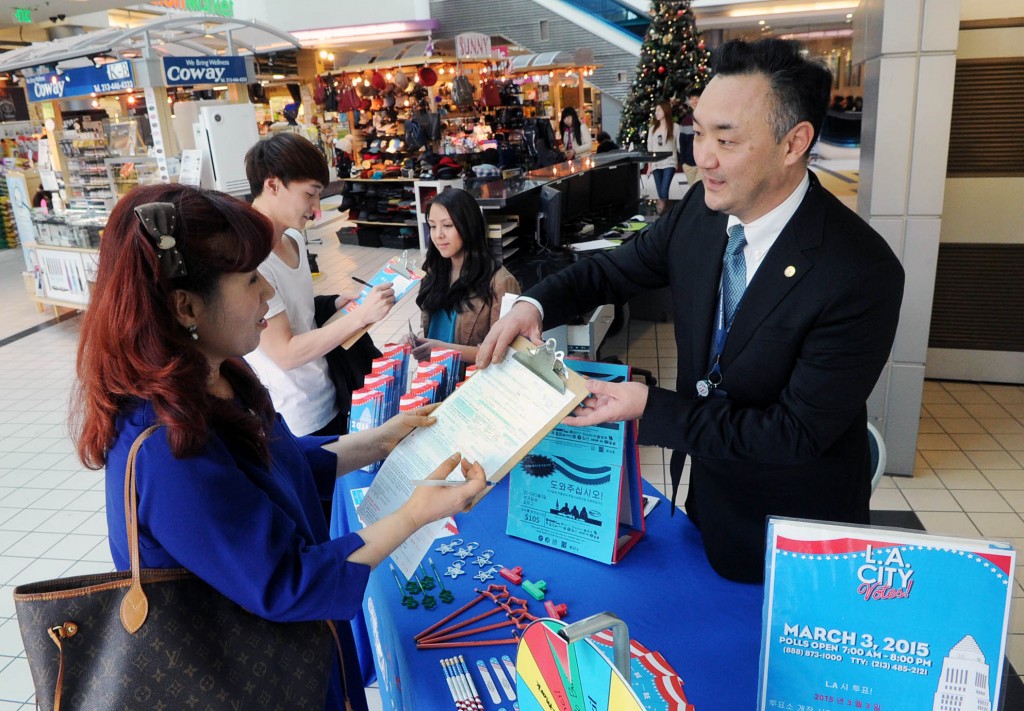 Workers urge Korean Americans to register to vote in March 3 municipal elections inside a Korean market. (Park Sang-hyuk/Korea Times)