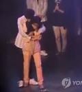 A Malaysian fan is hugged by a member of K-pop band B1A4 during a Kuala Lumpur fan event. (YouTube capture)