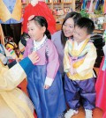 Inside Lee Hwa Traditional Dress Shop in Los Angeles' Koreatown Wednesday, shop manager Park So-young helped dress three children -- Ah-reum, 5, Jung-bin, 4, and Oh-reum, 7 -- in hanbok for Seollal. (Park Sang-hyuk/Korea Times)