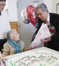Pastor Yun Jong-hun delivers a cake and flowers as Song Wun-hwa celebrates her 106th birthday. (Korea Times file)