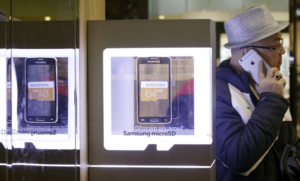 An advertisement of Samsung Electronics' micro SD cards is seen at a Samsung Electronics shop in Seoul, South Korea, Thursday, Jan. 29, 2015. Samsung Electronics Co. said lost the battle of the big phones last quarter as Apple's copycat large iPhone lured buyers in the crucial Chinese market. The South Korean company said Thursday its profit sank last quarter, with an improvement in its semiconductor business insufficient to mask its mobile problems. (AP Photo/Ahn Young-joon)
