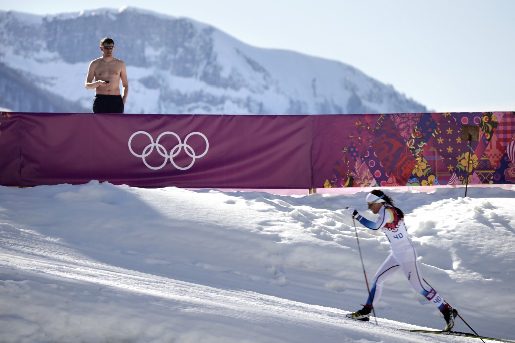 In this Feb. 13, 2014 file photo, a shirtless spectator watches Sweden's Charlotte Kalla compete during the women's 10K classical style cross-country race at the 2014 Winter Olympics in Krasnaya Polyana, Russia. Kalla won the silver medal. The photo was part of a series of images by photographer Jae C. Hong which won the Thomas V. diLustro best portfolio award for 2014 given out by the Associated Press Sports Editors during their annual winter meeting in Orlando, Fla. (AP Photo/Jae C. Hong)