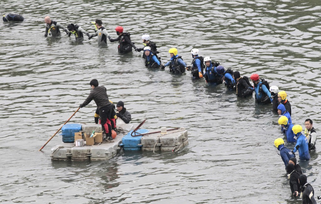 Search and rescue divers continue to search for missing persons at the site of a commercial plane crash in Taipei, Taiwan, Friday, Feb. 6, 2015. TransAsia Airways Flight 235 with 58 people aboard clipped a bridge shortly after takeoff and crashed into a river in the island's capital of Taipei on Wednesday morning. (AP Photo/Wally Santana)