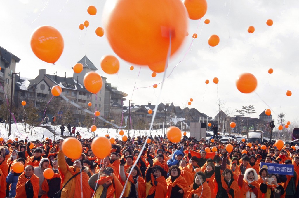 Participants release balloons to celebrate  an event marking the three-year countdown to the start of the 2018 Winter Olympics in Pyeongchang, South Korea, Monday, Feb. 9, 2015. The South Korean government recently rejected a proposal by the International Olympic Committee to halt construction on a new bobsled, luge and skeleton venue and relocate the events to an existing sliding center in another country. The IOC said the move would have saved $120 million in construction costs and $3.5 million in yearly maintenance fees.(AP Photo/Yonhap, Han Jong-chan)