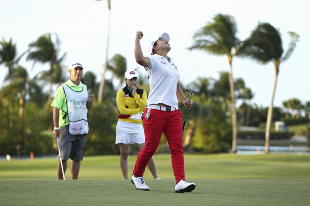 Second place finisher Sun Young Yoo of South Korea, background in yellow, watches Sei Young Kim of South Korea, pump her fist in the air after winning the Pure Silk Bahamas LPGA Classic at the Ocean Club Golf Course, in Paradise Island, Bahamas, Sunday, Feb. 8, 2015. (AP Photo/Tim Aylen)