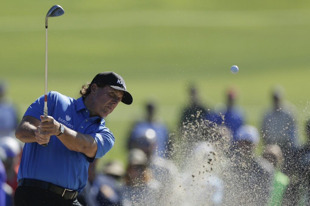 Phil Mickelson hits out of a bunker on the 11th hole of the North Course at Torrey Pines during the second round of the Farmers Insurance Open golf tournament Friday, Feb. 6, 2015, in San Diego. (AP Photo/Gregory Bull)