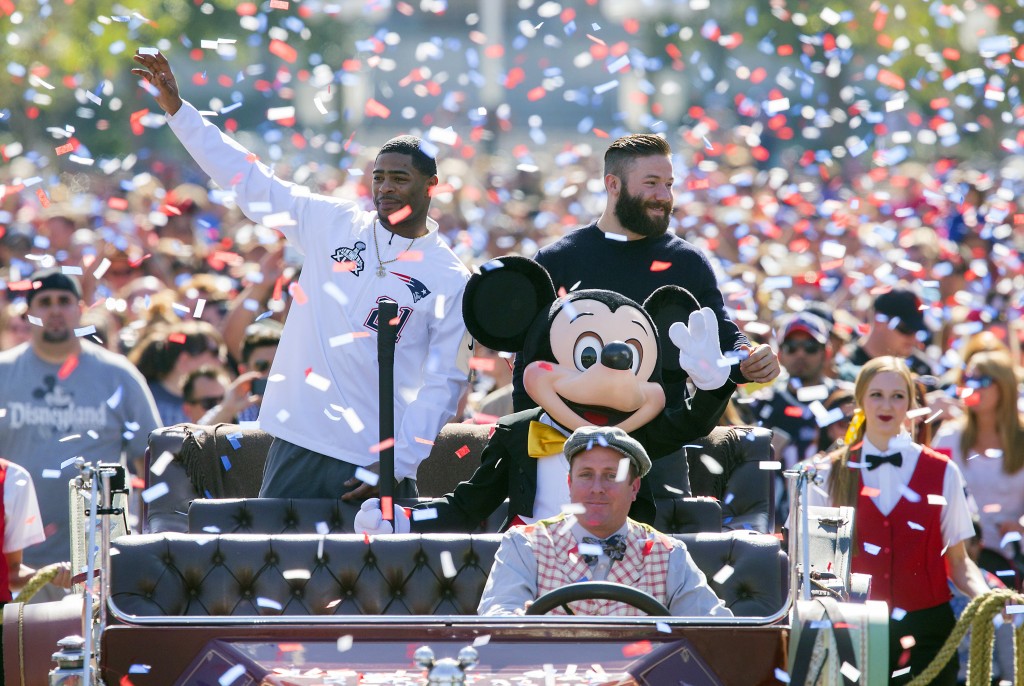 In this image provided by Disneyland, New England Patriots players Julian Edelman, right, and Malcolm Butler join Mickey Mouse as they celebrated their teams Super Bowl XLIX championship victory over the Seattle Seahawks at Disneyalnd park in Anaheim, Calif., on Monday, Feb. 2, 2015. (AP Photo/Disneyland, Paul Hiffmeyer)