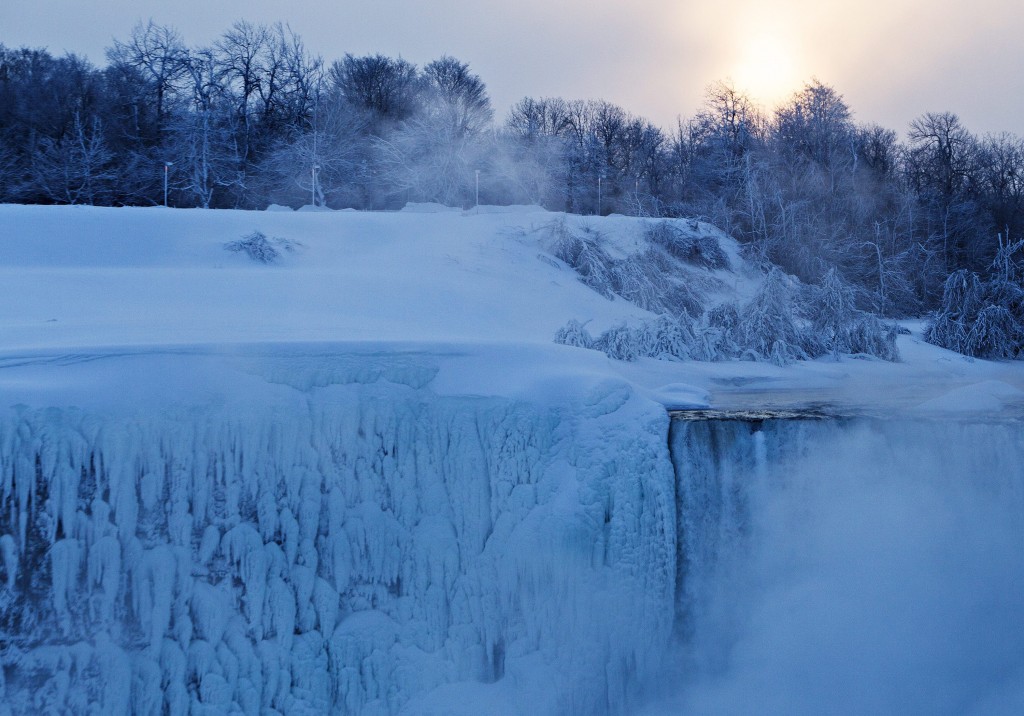 The sun rises over masses of ice formed around the Canadian 'Horseshoe' Falls in Niagara Falls, Ontario, Canada, Thursday, Feb. 19, 2015. (AP Photo/The Canadian Press,Aaron Lynett)