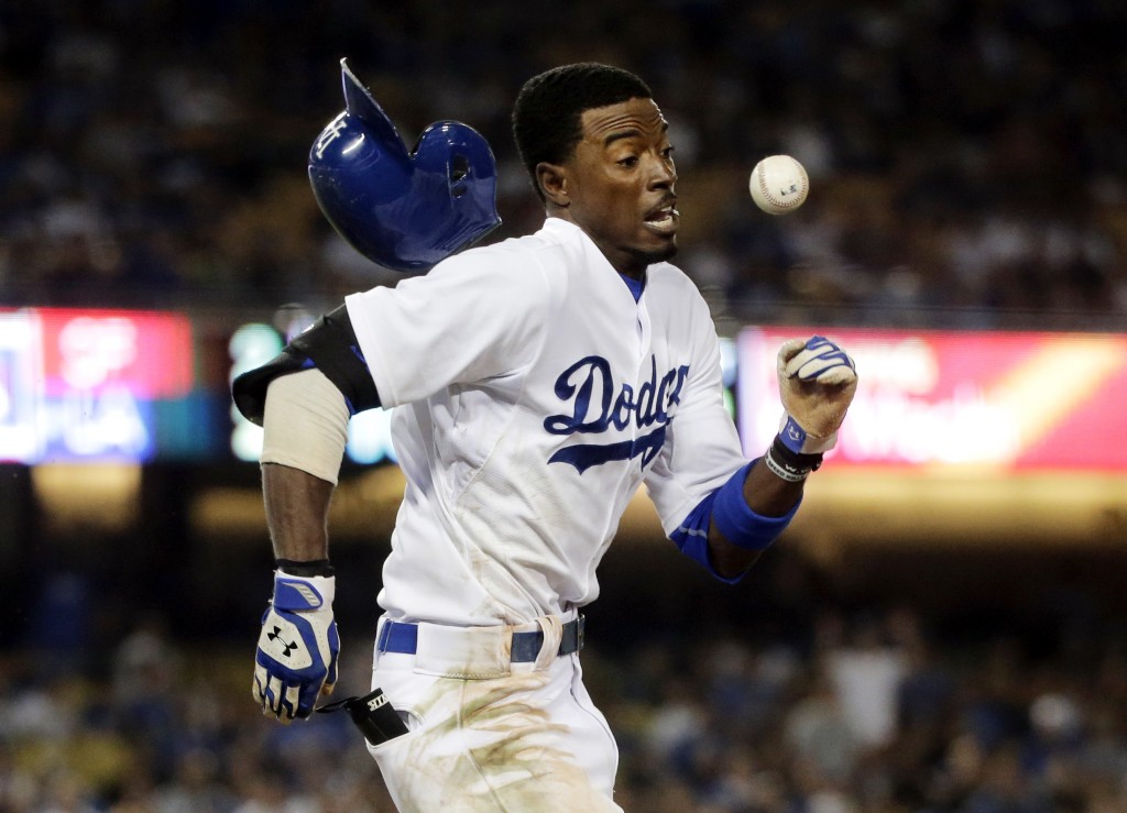 In this Sept. 22, 2014 file photo, Los Angeles Dodgers' Dee Gordon runs to first base with the throw during the 10th inning of a baseball game against the San Francisco Giants in Los Angeles. Gordon was out at first. The photo was part of a series of images by photographer Jae C. Hong which won the Thomas V. diLustro best portfolio award for 2014 given out by the Associated Press Sports Editors during their annual winter meeting in Orlando, Fla. (AP Photo/Jae C. Hong)