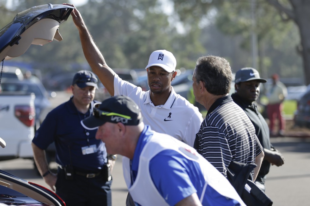 Tiger Woods loads his car after withdrawing in the first round of the Farmers Insurance Open golf tournament Thursday, Feb. 5, 2015, in San Diego. (AP Photo/Gregory Bull)