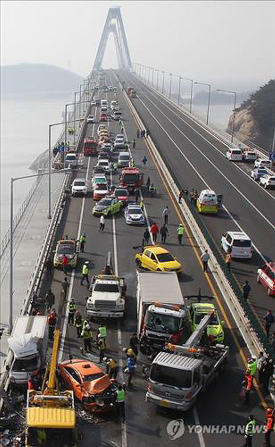 Authorities investigate the scene of a 100-car collision on the Yeongjong Bridge connecting the western port city of Incheon to Incheon International Airport on an island on Feb. 11, 2015. (Yonhap)