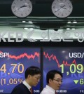 Currency traders pass by screens showing the Korea Composite Stock Price Index (KOSPI) and foreign exchange rate, right, at the foreign exchange dealing room of the Korea Exchange Bank headquarters in Seoul, South Korea, Friday, Jan. 9, 2015. Asian stocks extended gains Friday after other global markets bounced back from a rocky start to the year and oil prices stabilized after dramatic plunges. The Korea Composite Stock Price Index rose 1.05 percent, or 20.05, to close at 1,924.70. (AP Photo/Ahn Young-joon)