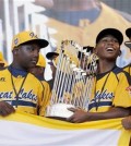 FILE - In this Aug. 27, 2014, file photo, members of the Jackie Robinson West Little League baseball team participate in a rally in Chicago celebrating the team's U.S. Little League Championship. Little League International has stripped Chicago's Jackie Robinson West team of its national title after finding the team falsified its boundary map. The league made the announcement Wednesday morning, Feb. 11, 2015, saying the Chicago team violated regulations by placing players on the team who didn’t qualify because they lived outside the team’s boundaries. Little League International also suspended Jackie Robinson West manager Darold Butler from league activity.(AP Photo/Charles Rex Arbogast, File)