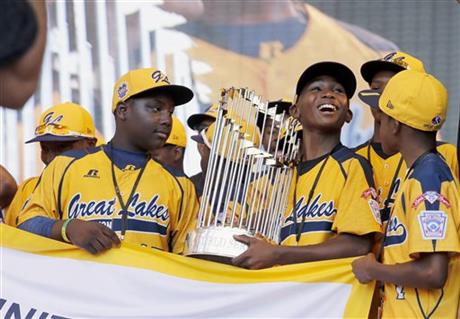 FILE - In this Aug. 27, 2014, file photo, members of the Jackie Robinson West Little League baseball team participate in a rally in Chicago celebrating the team's U.S. Little League Championship. Little League International has stripped Chicago's Jackie Robinson West team of its national title after finding the team falsified its boundary map. The league made the announcement Wednesday morning, Feb. 11, 2015, saying the Chicago team violated regulations by placing players on the team who didn’t qualify because they lived outside the team’s boundaries. Little League International also suspended Jackie Robinson West manager Darold Butler from league activity.(AP Photo/Charles Rex Arbogast, File)