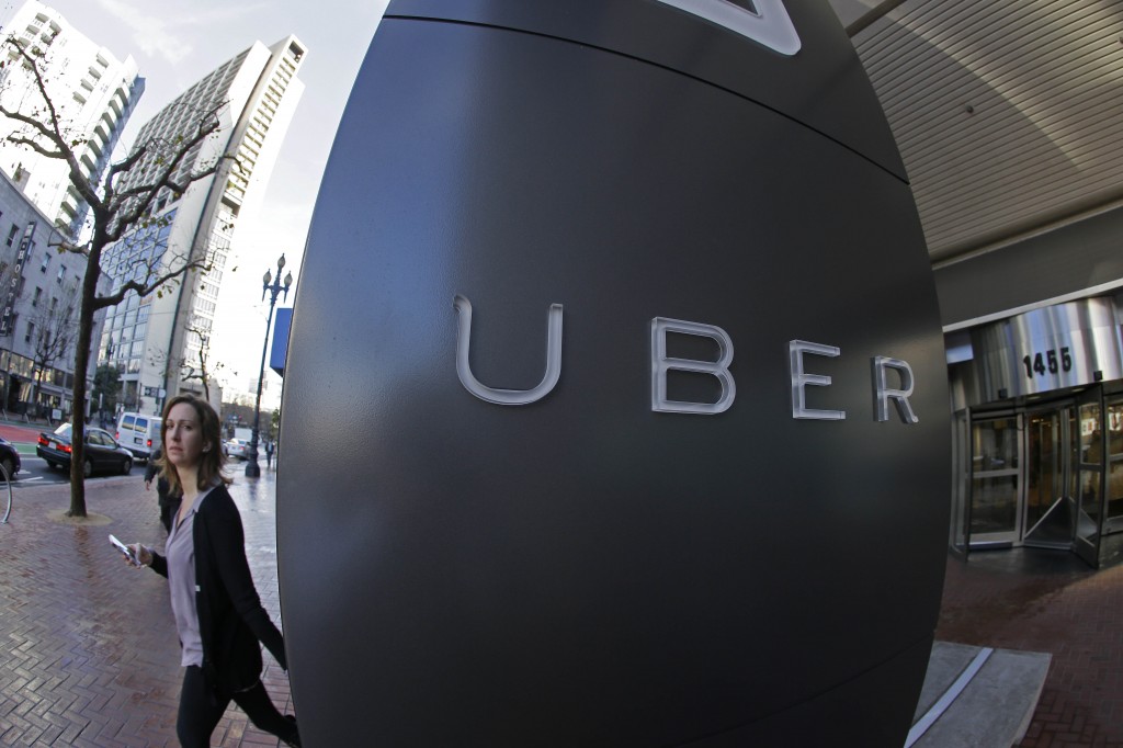 A woman leaves the headquarters of Uber in San Francisco. Venture capitalists poured a whopping $48.3 billion into U.S. startup companies last year, investing at levels that haven't been seen since before the dot-com bubble burst in 2001, according to a new report issued Friday, Jan. 16, 2015. The two biggest deals in 2014 were separate rounds of investment in Uber Technologies, the high-flying and controversial ride-hailing service, now valued at $41 billion. (AP Photo/Eric Risberg)