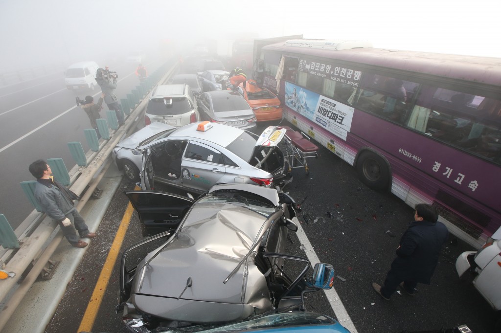 Damaged vehicles sit on Yeongjong Bridge in Incheon, South Korea, Wednesday, Feb. 11, 2015. Two people were killed and at least 42 were injured on Wednesday after a pileup involving about 100 vehicles in foggy weather on the bridge near the Incheon International Airport, South Korean officials said.(AP Photo/Yonhap, Suh Myung-gon) 