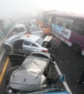 Damaged vehicles sit on Yeongjong Bridge in Incheon, South Korea, Wednesday, Feb. 11, 2015. Two people were killed and at least 42 were injured on Wednesday after a pileup involving about 100 vehicles in foggy weather on the bridge near the Incheon International Airport, South Korean officials said.(AP Photo/Yonhap, Suh Myung-gon)