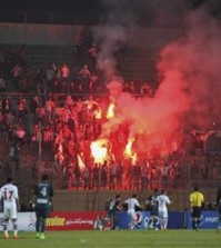 Soccer fans hold lit flares at the stand as they watch a match between Egyptian Premier League clubs Zamalek and ENPPI at Air Defense Stadium in a suburb east of Cairo, Egypt, Sunday, Feb. 8, 2015. A riot broke out Sunday night outside of the major soccer game, with a stampede and fighting between police and fans killing at least 22 people, authorities said. (AP Photo/Ahmed Abd El-Gwad, El Shorouk newspaper)