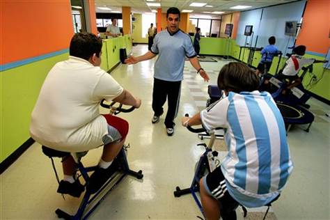 Puerto Rican children's fitness expert Jose Ortiz helps train overweight boys on stationary bikes inside the gym he operates in Guaynabo, Puerto Rico. Statistics point to a growing generation of Puerto Rican children struggling with obesity and related diseases, once rarely seen among such young people. (AP)