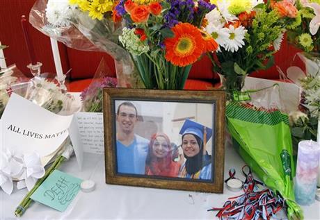 A makeshift memorial appears on display, Wednesday, Feb. 11, 2015, at the University of North Carolina School of Dentistry in Chapel Hill, N.C., in remembrance of Deah Shaddy Barakat, 23, Yusor Mohammad, 21, and Razan Mohammad Abu-Salha, 19, who were killed on Tuesday. Craig Stephen Hicks, 46, has been charged with three counts of first-degree murder in the case. (AP Photo/The News & Observer, Chris Seward)