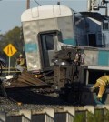 A firefighter climbs into the wreck of a Metrolink passenger train that derailed, Tuesday, Feb. 24, 2015, in Oxnard, Calif. Three cars of the Metrolink train tumbled onto their sides, injuring dozens of people in agricultural country 65 miles northwest of Los Angeles. Metrolink spokesman Scott Johnson told the Los Angeles Times that at least 30 people were injured. (AP Photo/Mark J. Terrill)