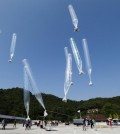 North Koran defectors release balloons carrying leaflets condemning North Korean leader Kim Jong Un and his government's policies, in Paju, near the border with North Korea, South Korea, Friday, Oct. 10, 2014. The activists launched balloons carrying about 200,000 anti-North Korea leaflets over the border on Friday when North Korea marks the 69th anniversary of the founding of the ruling Workers' Party. (AP Photo/Ahn Young-joon)