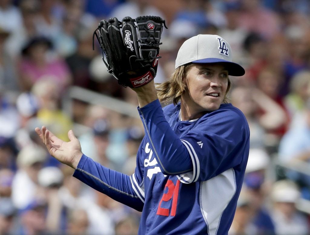 Los Angeles Dodgers starting pitcher Zack Greinke reacts after a fly ball goes over his head during the second inning of a spring training baseball exhibition game against the Chicago Cubs in Mesa, Ariz., on Wednesday, March 11, 2015. (AP Photo/Chris Carlson)
