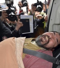 A suspect, identified by police as 55-year-old Kim Ki-jong, is carried on a stretcher off an ambulance as he arrives at a hospital in Seoul, South Korea, Thursday, March 5, 2015. Lippert was in stable condition after a man screaming demands for a unified North and South Korea slashed him on the face and wrist with a knife, South Korean police and U.S. officials said Thursday.(AP Photo/Yonhap, Han Jong-chan)