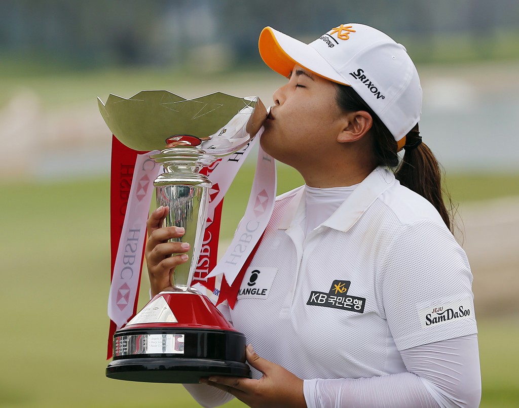 Park Inbee of South Korea kisses the trophy when prompted by organizers as she celebrates after winning the HSBC Women's Champions golf tournament on Sunday, March 8, 2015 in Singapore. (AP Photo/Wong Maye-E)