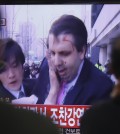 South Korean men watch a TV news program reporting U.S. Ambassador to South Korea Mark Lippert injured in a knife attack at Seoul railway station in Seoul, South Korea, Thursday, March 5, 2015. Lippert was slashed on the face and wrist by a man wielding a weapon with a 10-inch blade and screaming that the rival Koreas should be unified, South Korean police said. (AP Photo/Ahn Young-joon)