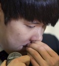 Former Olympic swimming champion Park Tae-hwan of South Korea holds back his tears during a news conference in Seoul, South Korea, Friday, March 27, 2015. Former Olympic swimming champion Park Tae-hwan of South Korea offered a public apology Friday, four days after receiving an 18-month ban for failing a doping test. (AP Photo/Lee Jin-man)