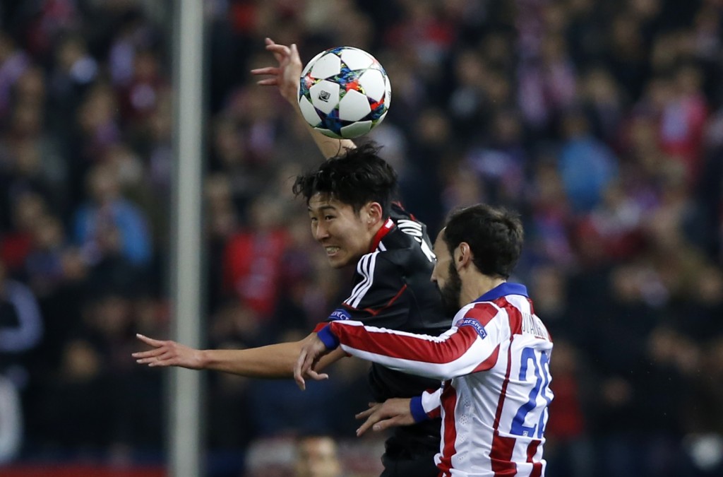 Leverkusen's Son Heung-min, left and Atletico's Juanfran hump for a high ball during the Champions League round of sixteen second leg soccer match between Atletico de Madrid and Bayer 04 Leverkusen at the Vicente Calderon stadium in Madrid, Spain, Tuesday, March 17, 2015. (AP Photo/Andres Kudacki)