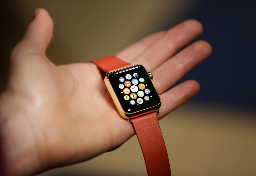 A woman holds the Apple Watch Edition during a demo following an Apple event Monday, March 9, 2015, in San Francisco. Make calls, read email, control music, manage Instagram photos, keep up with your workout, pay for groceries, open your hotel room door. CEO Tim Cook says you can do it all from your wrist with Apple Watch — for 18 hours a day. That's how long the battery will last on an average day. (AP Photo/Eric Risberg)
