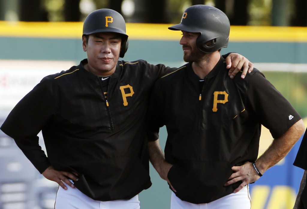 Pittsburgh Pirates shortstop Jung Ho Kang, of South Korea, left, visits with Steve Lombardozzi while waiting to participate in a base running drill before a spring training exhibition baseball game against the New York Yankees in Bradenton, Fla., Thursday, March 5, 2015.  (AP Photo/Gene J. Puskar)