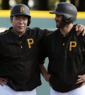 Pittsburgh Pirates shortstop Jung Ho Kang, of South Korea, left, visits with Steve Lombardozzi while waiting to participate in a base running drill before a spring training exhibition baseball game against the New York Yankees in Bradenton, Fla., Thursday, March 5, 2015.  (AP Photo/Gene J. Puskar)