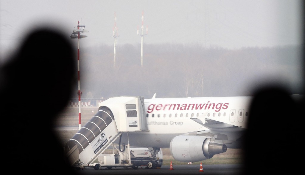 People look at a Germanwings aircraft at the airport in Duesseldorf, Germany, Tuesday, March 24, 2015, after a Germanwings passenger jet carrying 150 people crashed in the French Alps region as it traveled from Barcelona to Duesseldorf. (AP Photo/Frank Augstein)