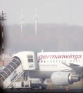 People look at a Germanwings aircraft at the airport in Duesseldorf, Germany, Tuesday, March 24, 2015, after a Germanwings passenger jet carrying 150 people crashed in the French Alps region as it traveled from Barcelona to Duesseldorf. (AP Photo/Frank Augstein)