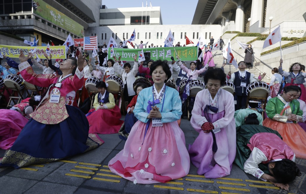 South Korean Christian women pray for the speedy recovery of U.S. Ambassador to South Korea Mark Lippert, during a gathering near the U.S. embassy in Seoul, South Korea, Saturday, March 7, 2015.  Police on Friday investigated the motive of the anti-U.S. activist they say slashed the U.S. ambassador to South Korea, as questions turned to whether security was neglected. (AP Photo/Ahn Young-joon)