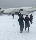 In this image provided by passenger Larry Donnell, a  New York Giants NFL football player, passengers are evacuated after a Delta plane skidded off the runway at LaGuardia Airport during a snowstorm, Thursday, March, 5 2015, in New York. Delta Flight 1086, carrying 125 passengers and five crew members, veered off the runway at around 11:10 a.m., authorities said. Six people suffered non-life-threatening injuries, said Joe Pentangelo, a spokesman for the Port Authority of New York and New Jersey, which runs the airport.  (AP Photo/Larry Donnell)