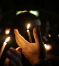 People take part in a candlelight vigil Thursday, March 12, 2015, in Ferguson, Mo. Two police officers were shot early Thursday morning in front of the Ferguson Police Department during a protest following the resignation of the city's police chief in the wake of a U.S. Justice Department report. (AP Photo/Jeff Roberson)