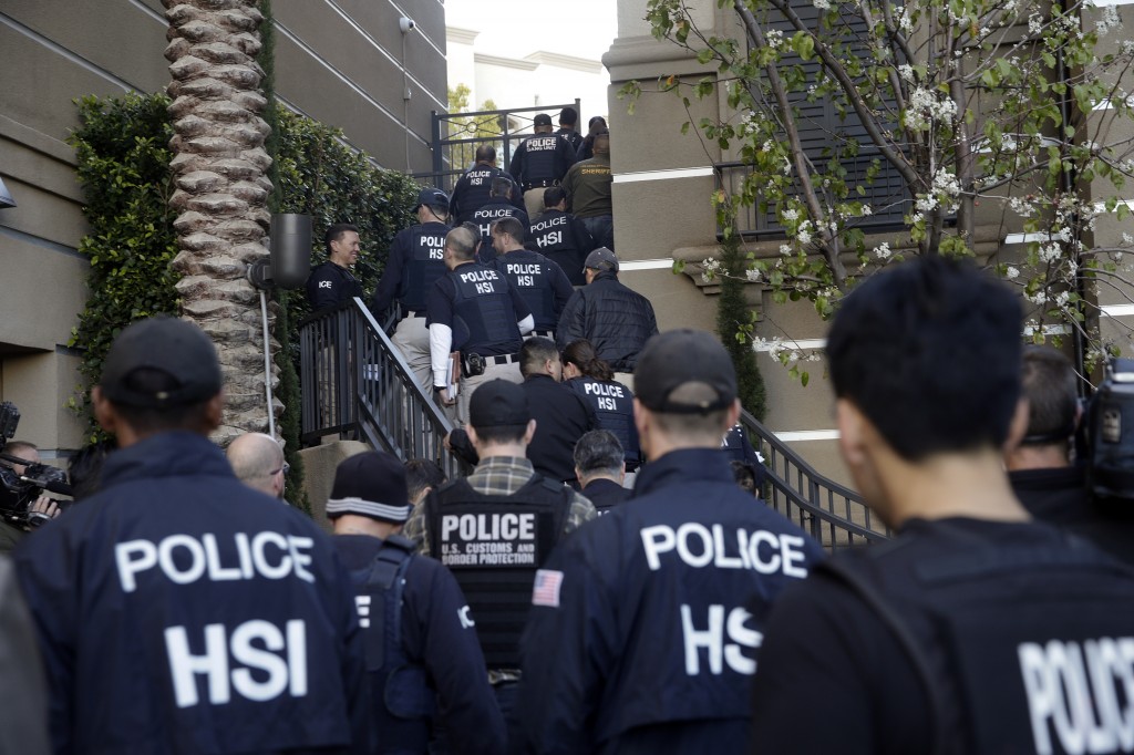 Federal agents enter an upscale apartment complex, Tuesday, March 3, 2015, in Irvine, Calif. Shortly after sunrise, federal agents swarmed the complex in the Orange County where authorities say a birth tourism business charged pregnant women $50,000 for lodging, food and transportation. The key draw for travelers is that the United States offers birthright citizenship. (AP Photo/Jae C. Hong)