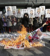 A South Korean conservative activist burns a North Korean flag, portraits of North Korea leader Kim Jon Un and Kim Ki-jong, the suspect of slashing U.S. Ambassador to South Korea Mark Lippert, during a rally demanding speedy recovery of Lippert near the U.S. embassy in Seoul, South Korea, Friday, March 6, 2015. A knife attack Thursday that injured Lippert is the latest act of political violence in a deeply divided country where some protesters portray their causes as matters of life and death. The letters at a banner read " A rally demanding speedy recovery of U.S. Ambassador to South Korea Mark Lippert  " (AP Photo/Ahn Young-joon)