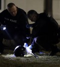 Police shine a light on a helmet as they investigate the scene where two police officers were shot outside the Ferguson Police Department Thursday, March 12, 2015, in Ferguson, Mo. (AP Photo/Jeff Roberson)