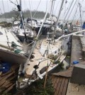 In this image provided by UNICEF Pacific, people on a dock view yachts damaged in Port Vila, Vanuatu, Saturday, March 14, 2015, in the aftermath of Cyclone Pam. Winds from the extremely powerful cyclone that blew through the Pacific\'s Vanuatu archipelago are beginning to subside, revealing widespread destruction. (AP Photo/UNICEF Pacific, Humans of Vanuatu)