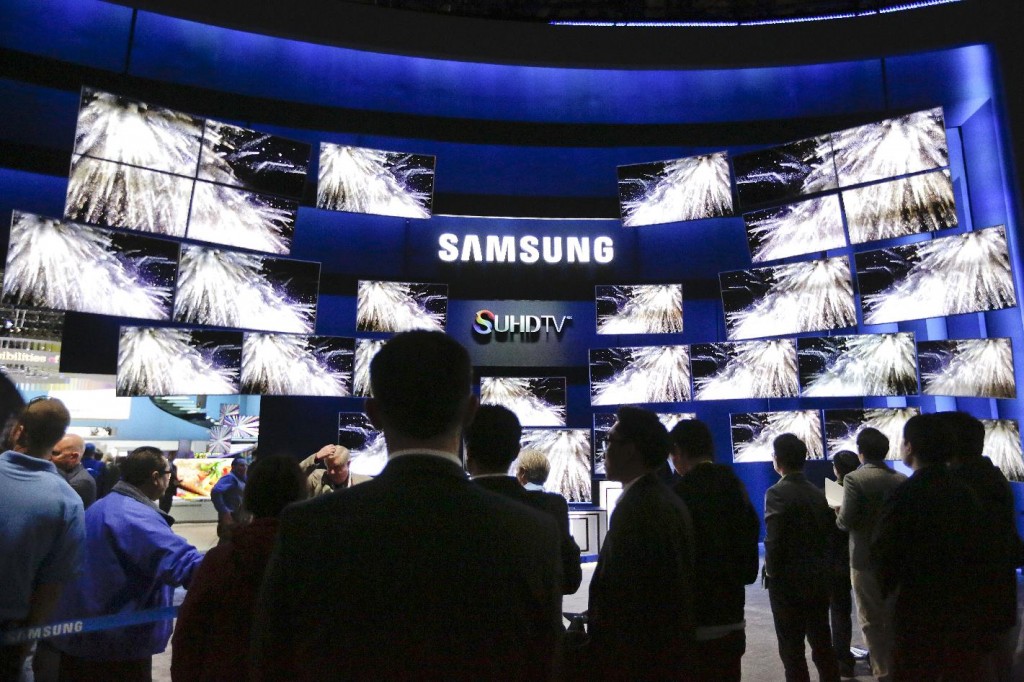 Attendees gather outside the Samsung booth, featuring its new SUHD TV, at the International CES Tuesday, Jan. 6, 2015, in Las Vegas. (AP Photo/Jae C. Hong)