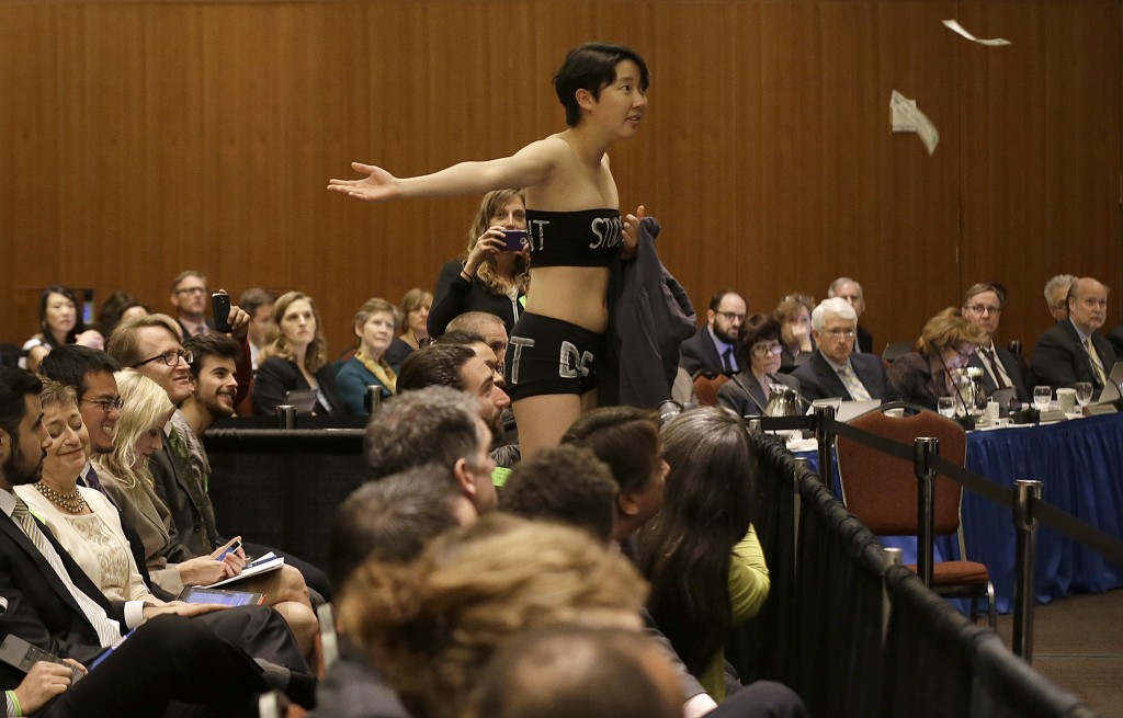 University of California Berkeley student Kristian Kim throws fake money while starting a protest during a UC Board of Regents meeting in San Francisco, Wednesday, March 18, 2015.   Gov. Jerry Brown has opposed  University of California President Janet Napolitano  plan to increase tuition by up to 5 percent in each of the next five years.(AP Photo/Jeff Chiu)