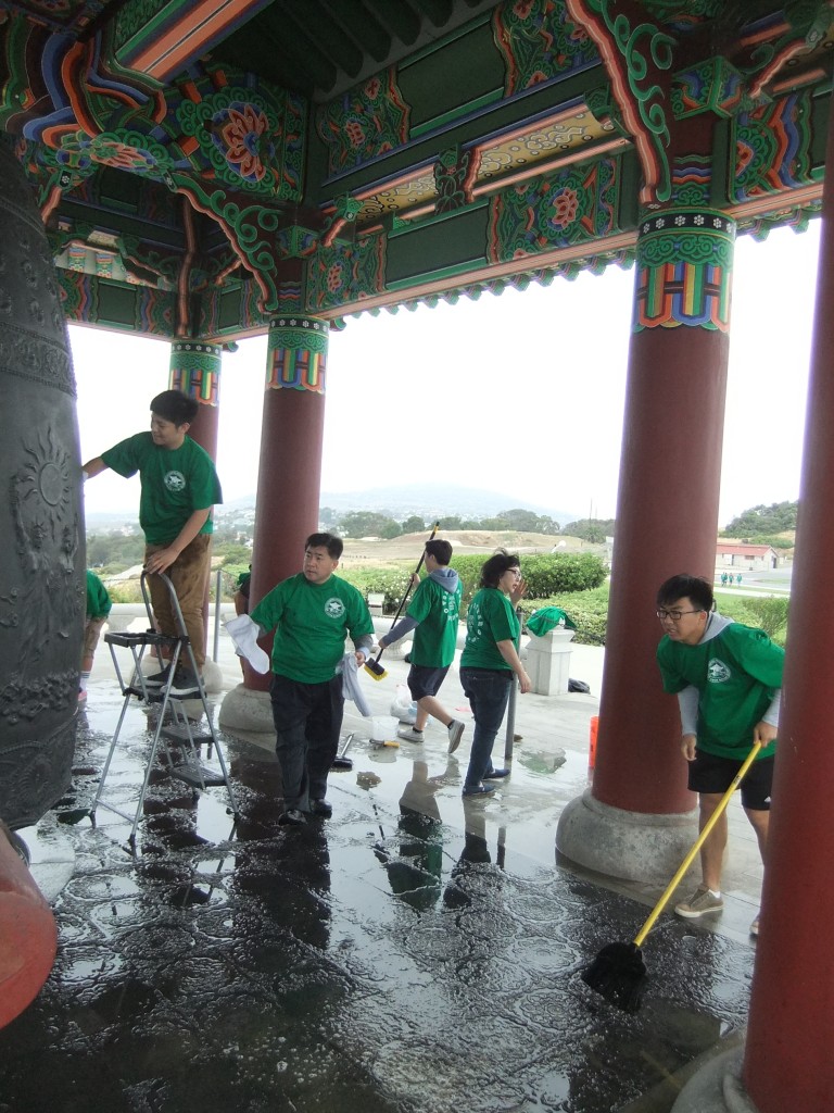 Student volunteers help clean the Korean Bell of Friendship in San Pedro, Calif., Saturday. (Kim Hyung-jae/Korea Times)
