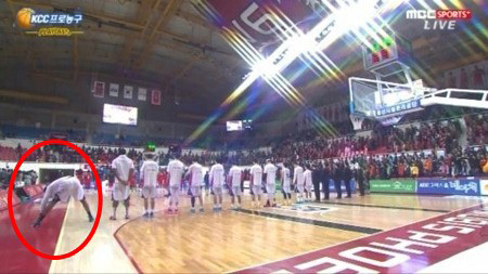 In this captured image, Changwon LG Sakers' Davon Jefferson, in red circle, stretches while Korea's national anthem is played before a Korean Basketball League playoff game against Ulsan Mobis Phoebus in Ulsan, on March 18. (Korea Times photo)